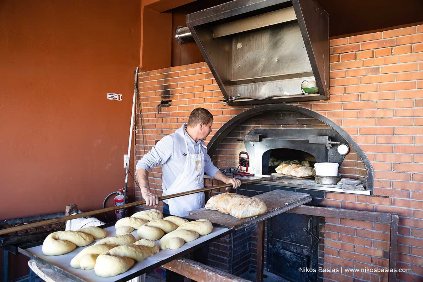 in an old oven, the baker is making buns